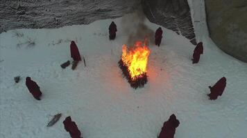 Gruppe von Mönche in der Nähe von das Feuer im das Berge beim Dämmerung, oben Sicht. Aufnahmen video