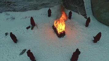 gruppo di monaci vicino il fuoco nel il montagne a crepuscolo, superiore Visualizza. metraggio video