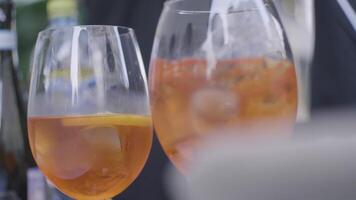 Soft, cold drinks at the wedding. Frame. Close-up of two glasses with orange coctails. video
