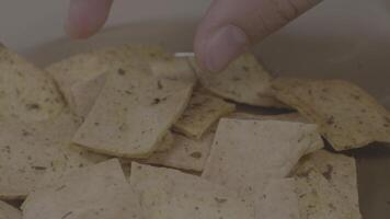 vrouw hand- nemen chips aardappelen van kan. hand- duurt een van aardappel chips van een metaal kom video
