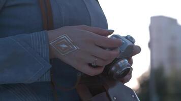 Girl's hands hold the vintage old film camera. Girl camera shutter clicks close up video