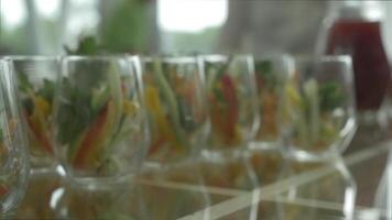 Close-up of green salad made of tomatoes, lettuce and crackers seasoned with mayonnaise in glasses. Verrines appetizer, cucumber, cream cheese, herbs, capers in glasses. Catering for party close up video