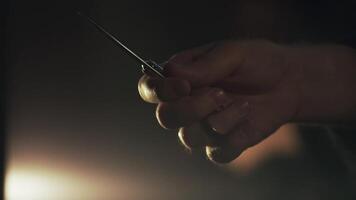 Barber twists the scissors in his hands close-up. Frame. Barber holds scissors in his hands video