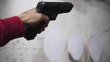 pistola è tiro avvicinamento. pistola nel mano avvicinamento. pistola essere tiro 1 volte. uomo spara un' nero pistola video