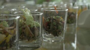 Close-up of green salad made of tomatoes, lettuce and crackers seasoned with mayonnaise in glasses. Verrines appetizer, cucumber, cream cheese, herbs, capers in glasses. Catering for party close up video