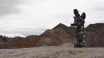 robot wandelen in een woestijn landschap. filmmateriaal. android robot in de berg woestijn in bewolkt weer video