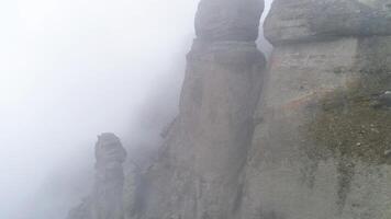 majestueux montagnes dans des nuages avec jaune, l'automne des arbres. tir. paysage avec magnifique haute rochers et spectaculaire brouillard avec Jaune des arbres, la nature Contexte. video