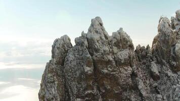 Close up for sharp rock formation on blue, cloudy sky background. Shot. Aerial for sharp peaks of mountain and a skyline on background. video