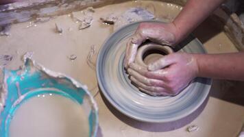 Top view of making of vase from clay. Stock footage. Close up of professional potter hands working with grey clay in workshop for making hand made pot. video