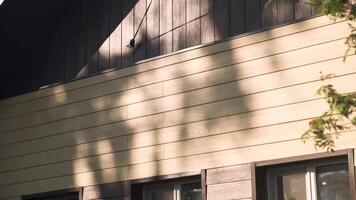 Facade of the countryside house near green tree. Stock footage. Summertime in the village with a wooden beautiful small cottage. video