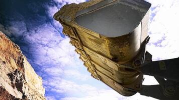 Loader machine unloading sand at eathmoving works at the construction site. Stock footage. Bottom view of the excavator flipping the bucket with soil and sand. video