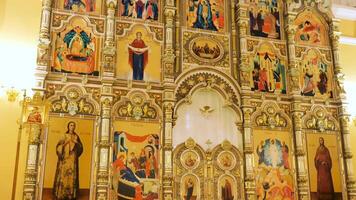 Rusland - Moskou 20.04.20. visie binnen van de orthodox kerk met goud iconostase tonen bijbels verhalen, geloof, architectuur en geloof concept. voorraad filmmateriaal. dichtbij omhoog van pictogrammen binnen de video