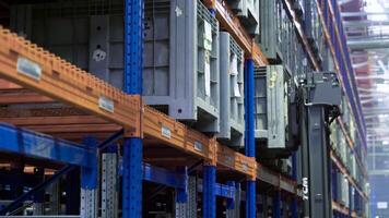 Working in factory warehouse. Scene. Technology for placing containers on shelves in warehouse of enterprise. Automated device lifts heavy load and places it on warehouse shelf video