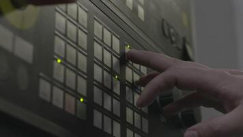Close up of a hand presses buttons on the control panel of industrial equipment. Stock footage. Side view of male hand pushing the button at the factory panel. video
