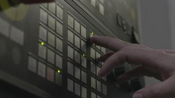 Close up of a hand presses buttons on the control panel of industrial equipment. Stock footage. Side view of male hand pushing the button at the factory panel. video