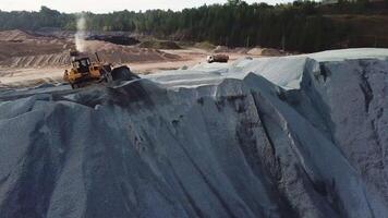 Aerial view of sand mining site conveyor with professional equipment at work. Stock footage. Flying above stone quarry with working heavy trucks and machines. video