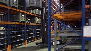 Russia - Moscow 15 March 2020. Warehouse in a factory with technical goods for mechanical engineering. Scene. Storing at warehouse shelves with workers using stacker trucks for boxes organization. video