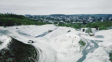 Aerial view of opencast mining quarry with lots of machinery at work. Stock footage. Flying over excavators and trucks at the quarry, heavy industry concept. video