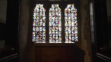 coloré verre les fenêtres dans vieux bâtiment. action. à l'intérieur médiéval bâtiment avec haute les fenêtres fabriqué de multicolore coloré verre mosaïques video