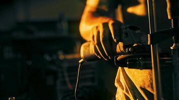 avvicinamento di fabbrica lavoratore lucidatura ferro parte. azione filmato. lavoratore con sporco mani lucidi ferro parte con mano levigatrice su buio sfondo. scintille a partire dal Lavorando con macinazione macchina video