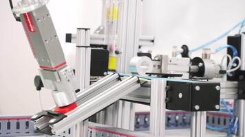 The robotic arms holding hollow tubes and putting them on the conveyor line. Scene. Automated machine placing sleeve details on the production lines. video