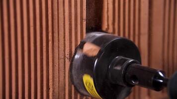 Close up of rotary hammer drilling a hole for outlets in red brick wall. Stock footage. Proffessional equipment at the construction site. video