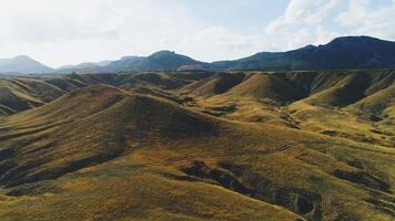Haut vue de montagneux vallée avec Jaune herbe sur Contexte de ciel. tir. désert paysage avec sec Jaune herbe de montagneux terrain video