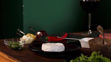 cerca arriba de el ingredientes y diferente salsas en el de madera mesa. valores imágenes. queso queso Camembert, rojo caliente chile pimienta , y verdor para hamburguesa preparación. video