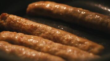 Close-up of thin long pork sausages in natural casing fried on the pan. Concept. Delicious grilled sausages video