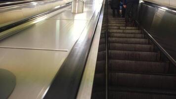 Close-up of people going down to the subway or underground train station by using the escalation. Concept. Urban transportation video