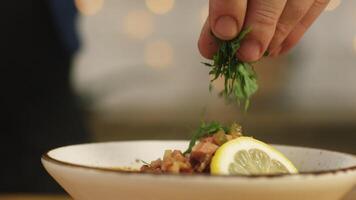 Close-up of some person's hand adding greens at the bowl with solyanka. Stock footage. Russian solyanka soup with meat, sausages and olives video