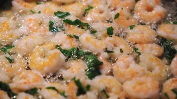 Close-up of fresh shrimps with basil fried in oil on a frying pan. Concept. Delicious seafood video