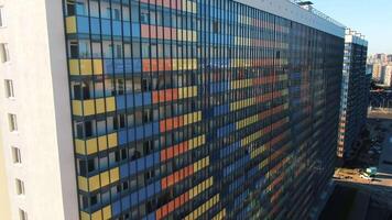 Close-up view facade of the beautiful colorful of a tall residential building. Motion. High-rise buildings modern architecture skyline. video