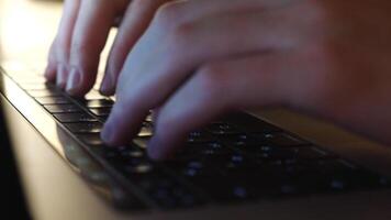 de cerca de masculino manos mecanografía en el ordenador portátil teclado con azul iluminación. concepto. trabajando en ordenador personal video