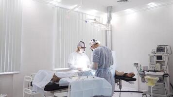 Two male surgeons at the work with time lapse effect. Action. Sedated patient lying on the table during surgical procedure inside the hospital room. video