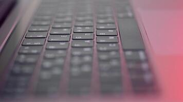 Close up of buttons on computer keyboard, macro background. Action. Black modern laptop buttons under the red lamp light, concept of technologies and devices. video