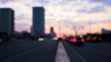 groot stad straat in de avond met bokeh en vervagen effect. concept. zonsondergang lucht, hoog stijgen gebouwen en in beweging auto's, stedelijk wazig landschap. video