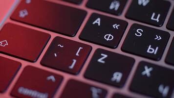 Close up of buttons on computer keyboard, macro background. Action. Black modern laptop buttons under the red lamp light, concept of technologies and devices. video