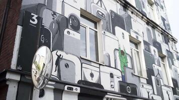 Exterior of the Flacon Design Factory pavilion. Art. Bottom view of the building wall decorated by the graffiti of many white, grey, and black smartphones. video