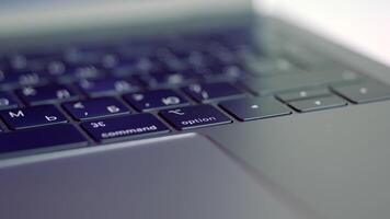 Close up of elegant modern laptop details. Action. Concept of modern technologies, Black keaboard and touch pad of a computer lying on white blurred background. video