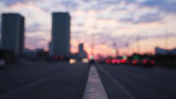 grande cidade rua dentro a tarde com bokeh e borrão efeito. conceito. pôr do sol céu, Alto subir edifícios e comovente carros, urbano borrado paisagem, atmosfera do romance. video