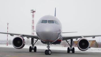 Plane rides on runway. Stock footage. Plane is preparing for takeoff moving along runway in winter. Plane on runway before flying abroad for vacation video