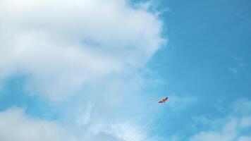 cerf-volant en volant dans le ciel parmi le des nuages. concept. bas vue de le été bleu ciel avec blanc des nuages et planant arc en ciel coloré cerf-volant, concept de liberté et enfance. video