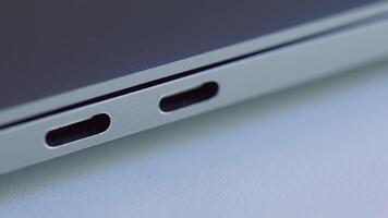 Close up of elegant modern laptop details. Action. Concept of modern technologies, USB port of a computer lying on white flat surface. video