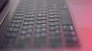 Perspective of a modern computer or laptop black keyboard on pink background, close up view. Action. New keypad with black buttons and white symbols on them, modern technologies concept. video