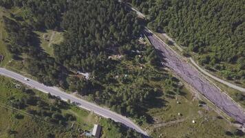 aéreo Visão do a estrada rural e floresta dentro verão. grampo. topo Visão do lindo verão montanhas vale com crescendo pinho árvores e uma dirigindo carro. video