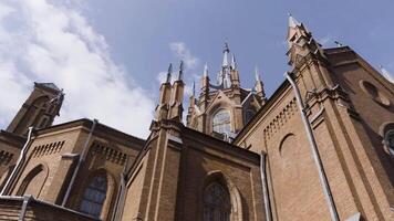 skön se av ett gammal katedral på blå molnig himmel bakgrund. handling. gammal historisk landmärke tillverkad av tegelstenar, begrepp av arkitektur. video