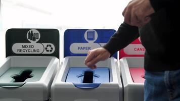 proche en haut de homme en mettant une le reçu dans une papier recyclage poubelle, recyclage échec. médias. concept de faux recyclé ordures, mal pour le environnement. video