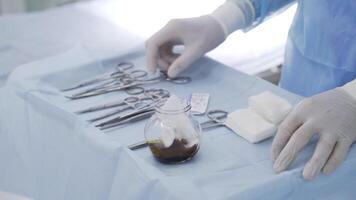 Close-up of surgeon preparing instruments for surgery. Action. Professional surgeon prepared various types of clips and scissors for complex operation video