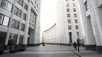 Low angle view of a city business dictrict. Action. Street with a beautiful modern office building with many windows and white facade, concept of architecture. video